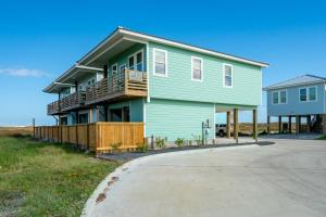 una casa verde al lado de una carretera en St Jo's Bungalow, en Port Aransas