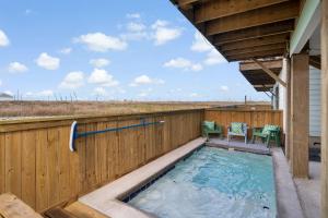 bañera de hidromasaje en una terraza con 2 sillas en St Jo's Bungalow, en Port Aransas