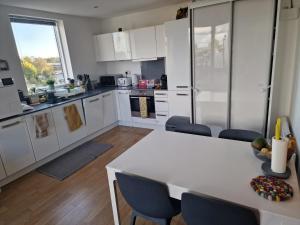 a kitchen with white cabinets and a table and chairs at Bright and Modern Forest Hill Flat - Flexible Stay in Forest Hill +8 photos