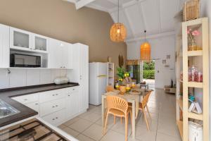 een keuken met witte kasten en een tafel met stoelen bij Paradiso Chikitu Little Paradise in Willemstad