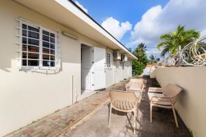 een rij stoelen buiten een huis bij Paradiso Chikitu Little Paradise in Willemstad