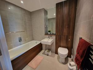 a bathroom with a toilet and a tub and a sink at Bright and Modern Forest Hill Flat - Flexible Stay in Forest Hill