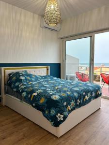 Un dormitorio con una cama con un edredón azul. en Appartement « pépite » vue mer, en Saint-Cyprien