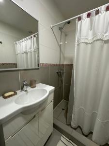 a white bathroom with a sink and a shower at Wow! Ushuaia Apartments in Ushuaia +38 photos