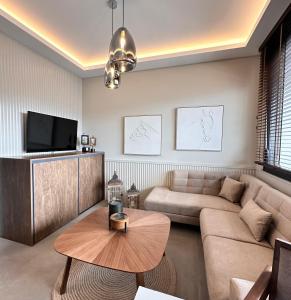 a living room with a couch and a table at Central Luxury Apartment Maison De Luxx A10 in Larisa