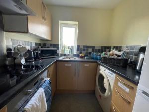a kitchen with a sink and a washing machine at Misk Homes #2 Near Heathrow Airport, shops & Brunel University - Free Parking in Uxbridge