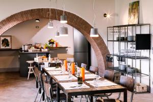 een eetkamer met tafels en stoelen en een bakstenen muur bij Salcheto WineHouse in Montepulciano