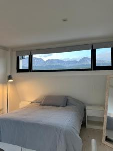 a bedroom with a bed with a large window at Wow! Ushuaia Apartments in Ushuaia