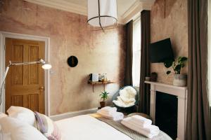 a bedroom with a bed and a fireplace at The Culpeper Bedrooms in London