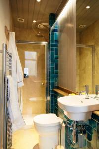 a bathroom with a toilet and a sink and a shower at The Culpeper Bedrooms in London