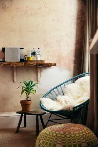 a room with a chair and a table with a plant at The Culpeper Bedrooms in London