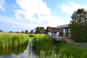 a house with a deck next to a body of water at Härmati Holiday House in Nasva