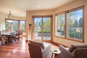 a living room with a table and chairs and windows at Drake Park Villa in Bend