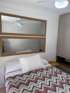 a bedroom with a bed with a mirror above it at Acean Garden in Cabo Frio