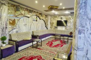 a room with a purple couch and a tv at Hotel Janat Al Naim in Karbala