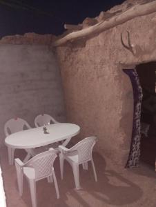 a white table and chairs in a room with a stairs at dar Brahim in Mhamid