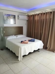 a bedroom with a bed with two towels on it at Cobertura Pôr do Sol in Saquarema