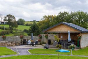 a gazebo with a table and chairs in a yard at Fulshaw Mill Holidays in Stewarton
