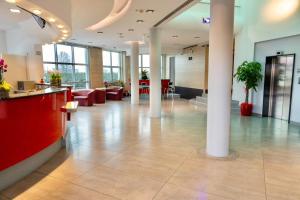 a lobby of a building with columns and a reception desk at Unico Hotel in Ossona