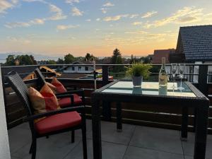 a table and chairs on a balcony with a bottle of wine at Eichenhöfe in Chieming