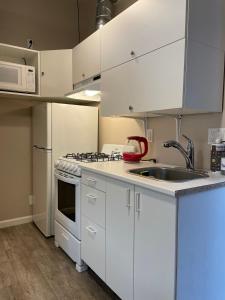 Una cocina con gabinetes blancos y un fregadero. en Love Shack, en Middletown