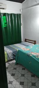 2 Betten in einem Zimmer mit grünem Vorhang in der Unterkunft Ultra in Ituzaingó