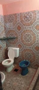 ein Badezimmer mit Toilette und blauem Eimer in der Unterkunft Ultra in Ituzaingó