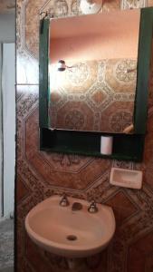 ein Badezimmer mit Waschbecken und Spiegel an der Wand in der Unterkunft Ultra in Ituzaingó