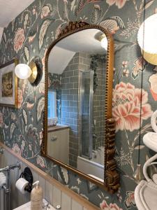 ein Badezimmer mit Spiegel und Blumentapete in der Unterkunft Mantlemas Cottage in Turners Hill + 70 Fotos