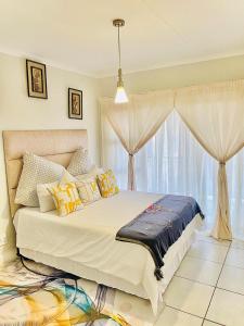 a bedroom with a large bed and a window at The Blyde Boutique Apartments in Pretoria