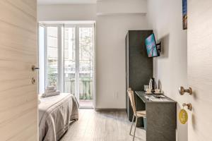 a bedroom with a bed and a desk and a window at Royal Rooms B&B in Naples