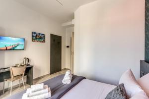 a bedroom with a bed and a desk and a tv at Royal Rooms B&B in Naples +61 photos