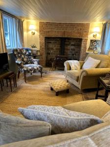 ein Wohnzimmer mit Couch und Kamin in der Unterkunft Mantlemas Cottage in Turners Hill