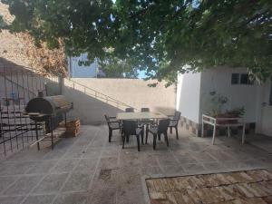 a patio with a table and chairs and a grill at La Damasca in General Roca