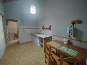 a kitchen with a sink and a table in a room at La Damasca in General Roca