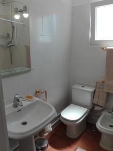 a white bathroom with a toilet and a sink at Sítio da Cornucópia Casa Principal in Moncarapacho +34 photos