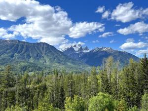 a view of a mountain range with trees and clouds at 2 Bedroom Basement Suite in Fernie by StayIn in Fernie