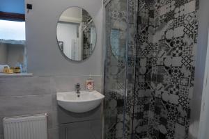 un bagno con lavandino e specchio di Tigin Dingle a Dingle