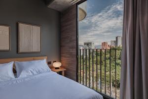 Postel nebo postele na pokoji v ubytování The Somos Loho Hotel