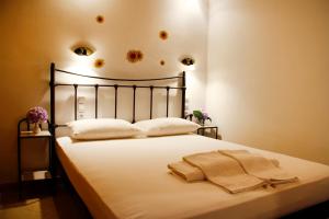 a bedroom with a bed with white sheets and pillows at Alisachni in Serifos Chora
