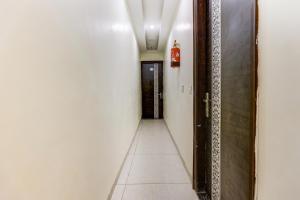 a corridor of a hallway with a door and a tile floor at Hotel O La Vista in Zirakpur +55 photos