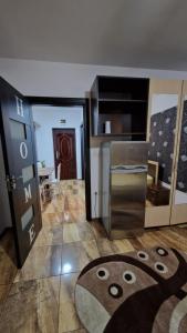 Una cocina con refrigerador y una puerta con una alfombra de Mickey Mouse. en Apartament Back, en Galaţi