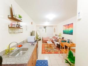 a kitchen with a sink and a living room at Urban Deca Homes Tondo Manila - by ADStaycation in Manila