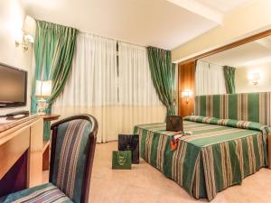 a hotel room with two beds and a television at Raeli Hotel Archimede in Rome