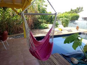 a hammock on a patio next to a pool at La Mare à Cuja in Sainte-Rose