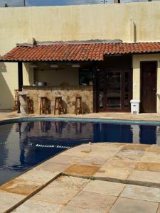 a house with a swimming pool in front of a building at Pousada Vila Italia - Porto da Dunas in Aquiraz