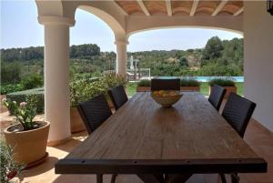 サン・ラファエル・デ・サ・クレウにあるVilla with charm and privacyのポーチに置かれた木製のテーブルと椅子、そしてフルーツの入ったボウル