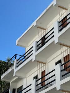 a white building with stairs on the side of it at Calma Chicha Rooms in Playa del Carmen