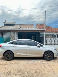 a white car parked in front of a house at Suite para até 4 pessoas cataratas in Foz do Iguaçu