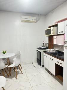a kitchen with a table and a stove and a table at Suite para até 4 pessoas cataratas in Foz do Iguaçu +5 photos